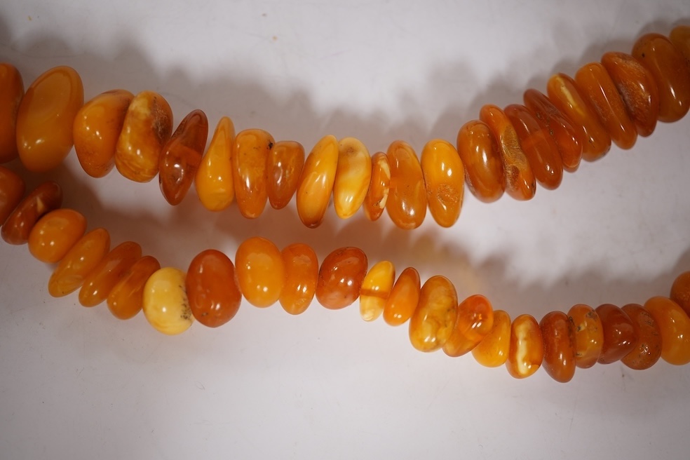 Three assorted amber necklaces including a single strand graduated oval bead necklace, 40cm, gross weight 37 grams, the other two necklaces gross weight 240 grams. Condition - poor to fair